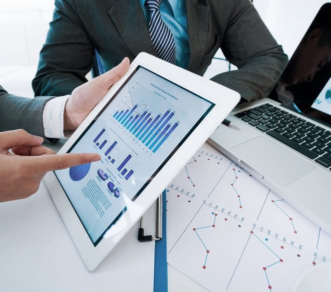 Group of executives discussing business activity graphs on tablet screen